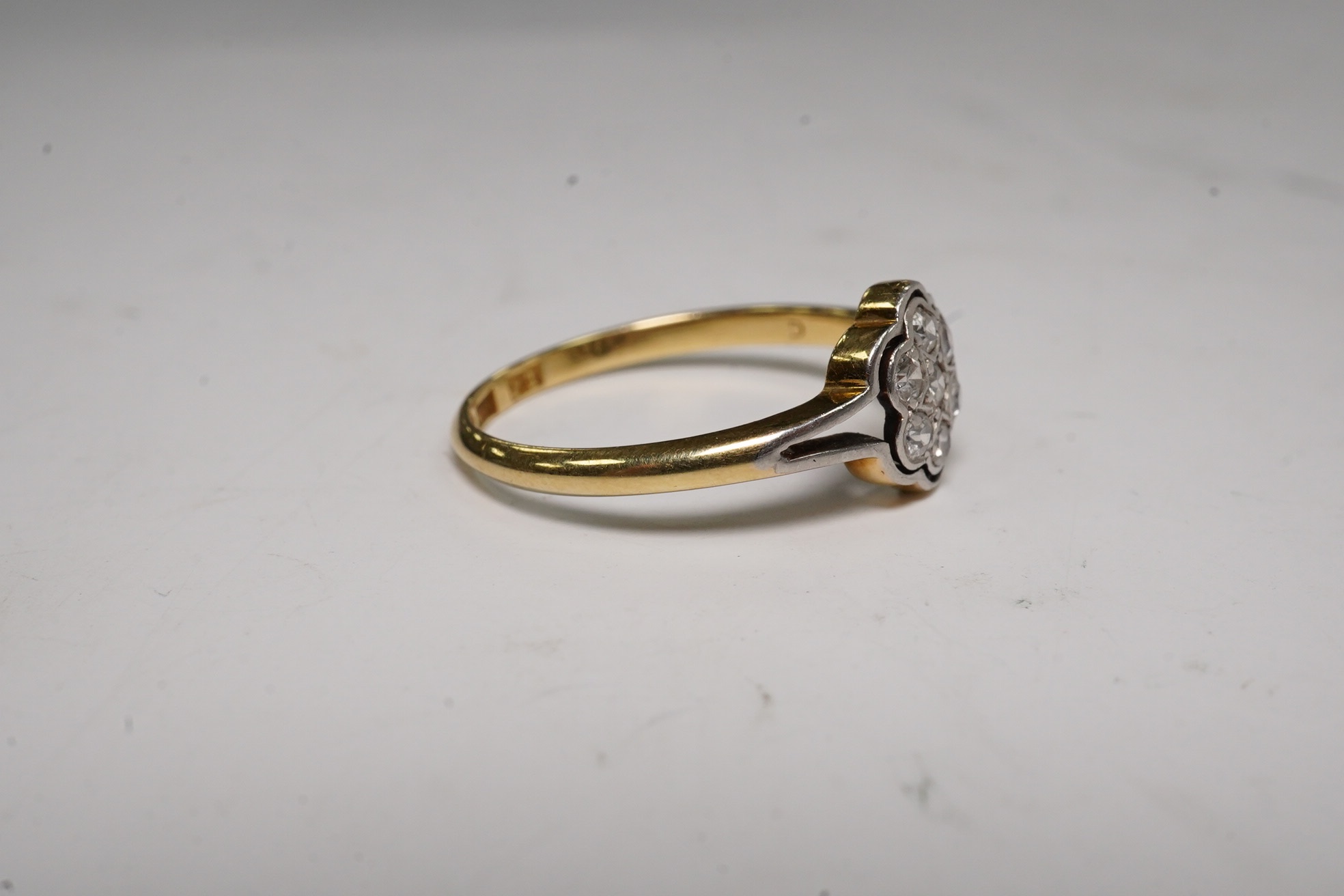 A 1940's 18ct, plat and diamond set flower head cluster ring, size O, gross weight 2.1 grams.